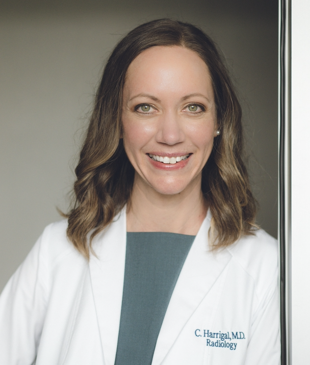 images shows the head and shoulders a light-skinned woman with shoulder length medium brown hair, light colored eyes smiling wearing a grey blouse and white lab coat